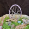 purple tree of life 3 inch compact size sitting in basket of rocks to show product in a garden setting